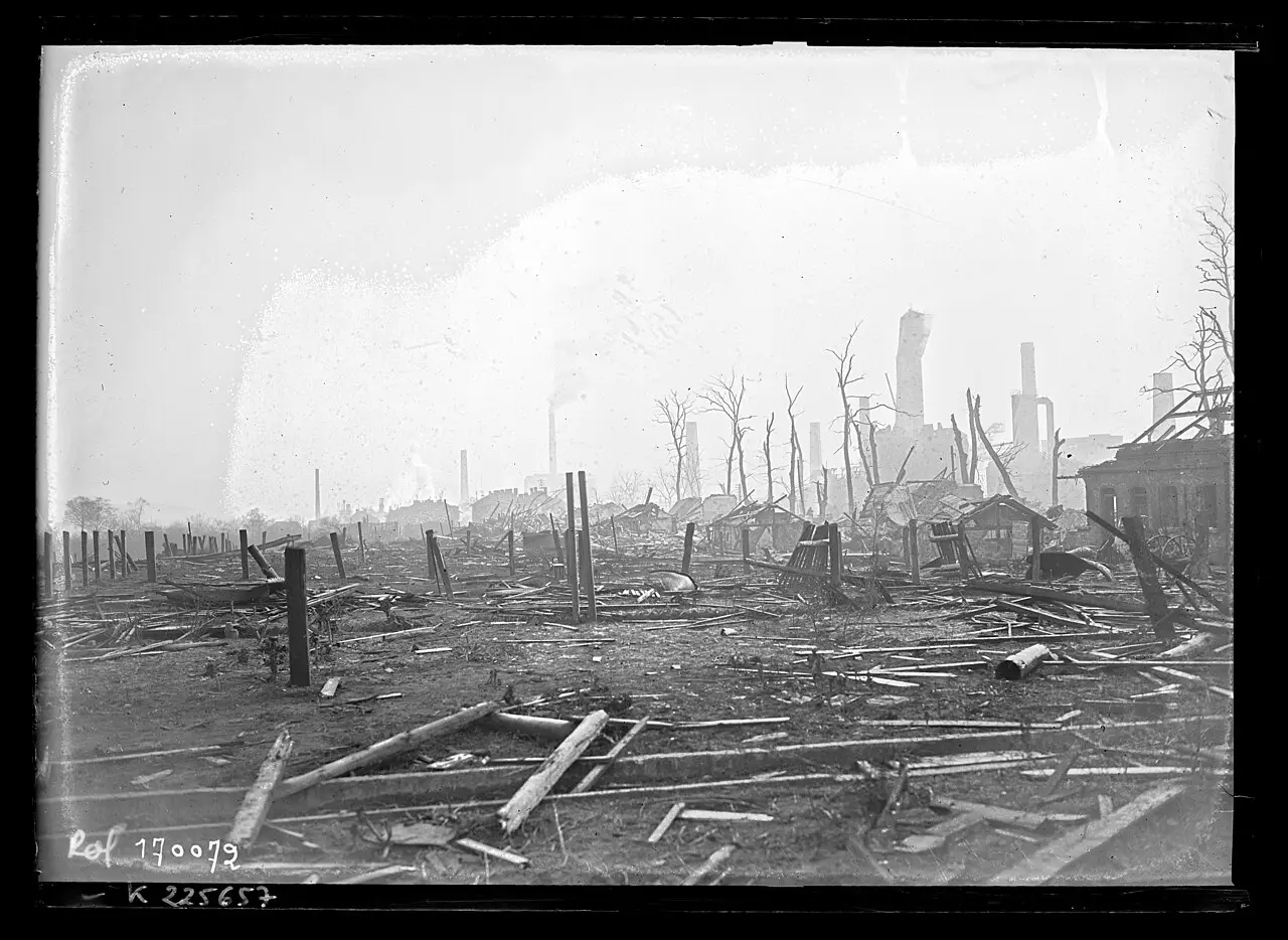 Ruined industrial buildings and rubble under a grey sky