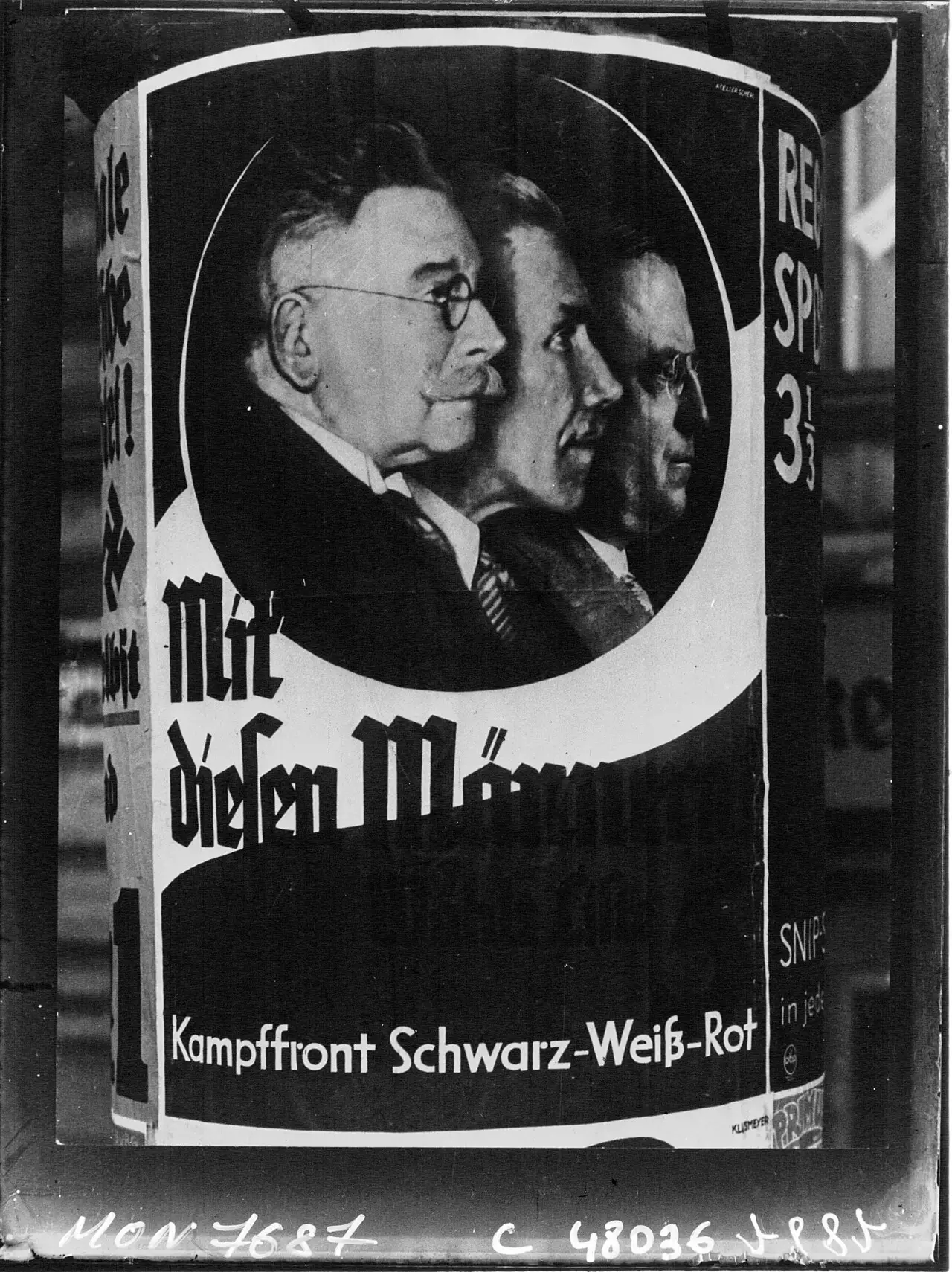 A poster on a round advertising column showing three men's heads in profile, one behind another, above a slogan in heavy black lettering