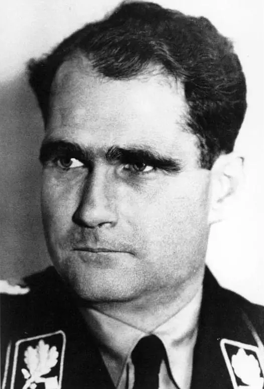 Close-up portrait of a dark-haired man with heavy eyebrows in a uniform collar with oak-leaf insignia.