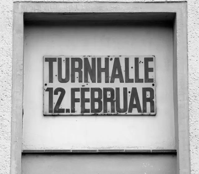 A metal sign with the words Turnhalle 12. Februar above a doorway