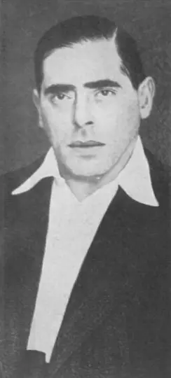 Head-and-shoulders photograph of a man with swept-back dark hair, wearing a suit and tie.