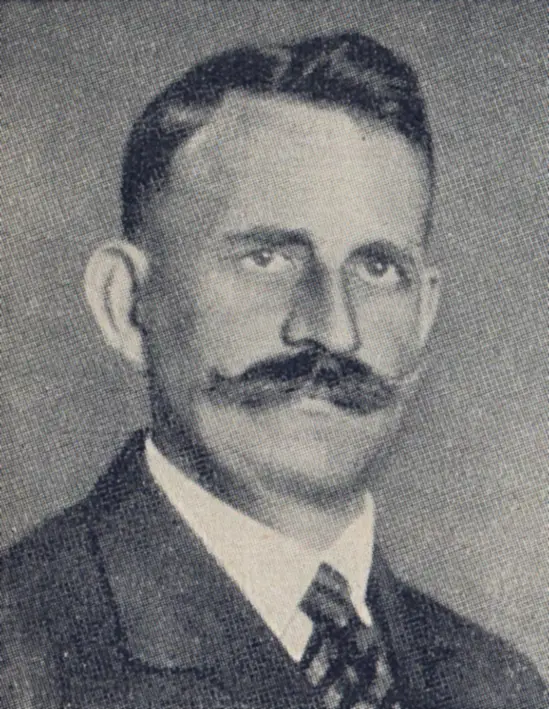 Portrait of a man with dark hair and a large moustache, in a suit and patterned tie