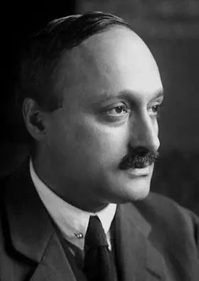 Head-and-shoulders portrait of a man with dark hair, wearing a suit and tie.