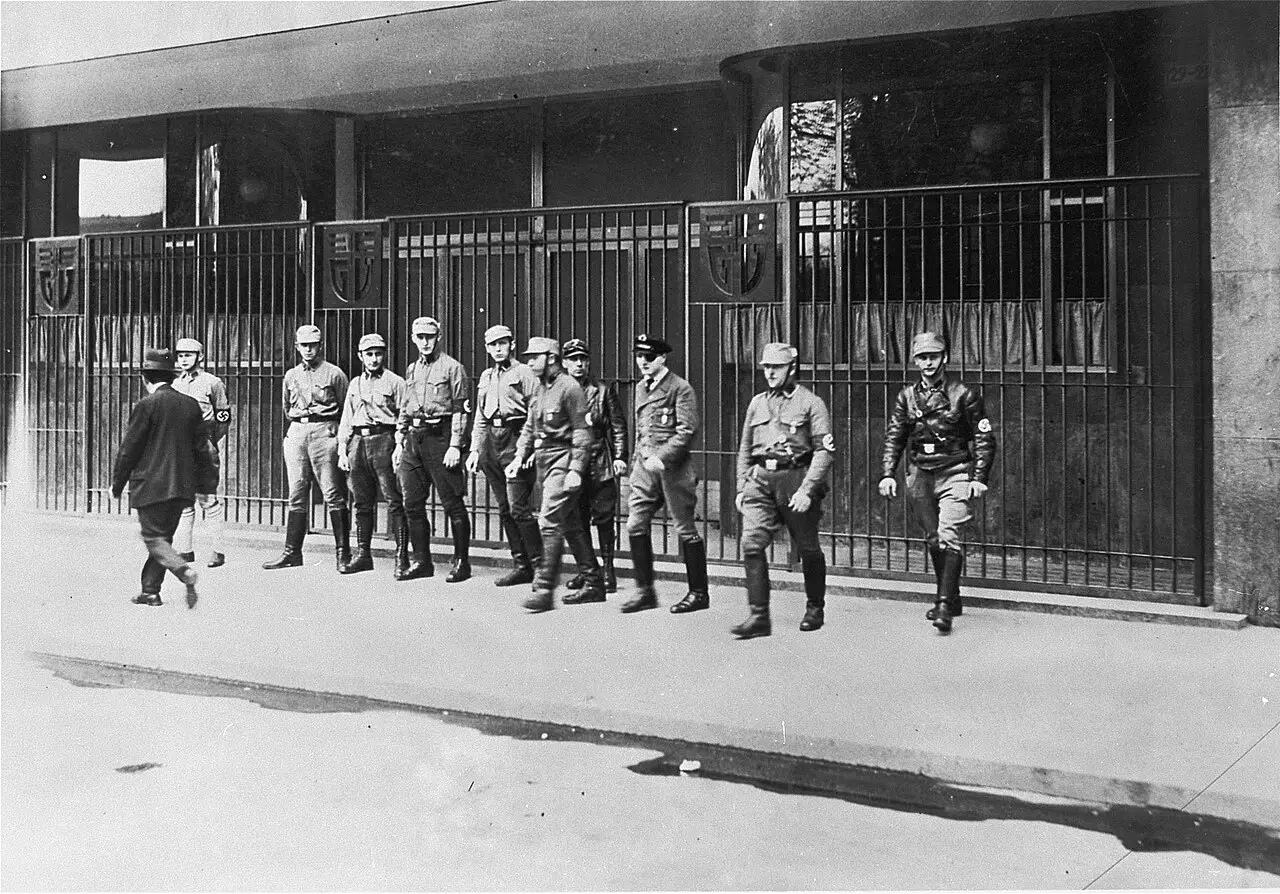 A line of uniformed SA men standing in front of the doorway of a large building