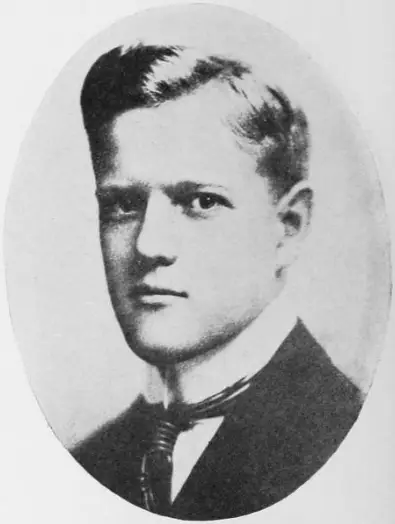 An oval head-and-shoulders portrait of a young man with swept-back fair hair, in a dark jacket and tie.